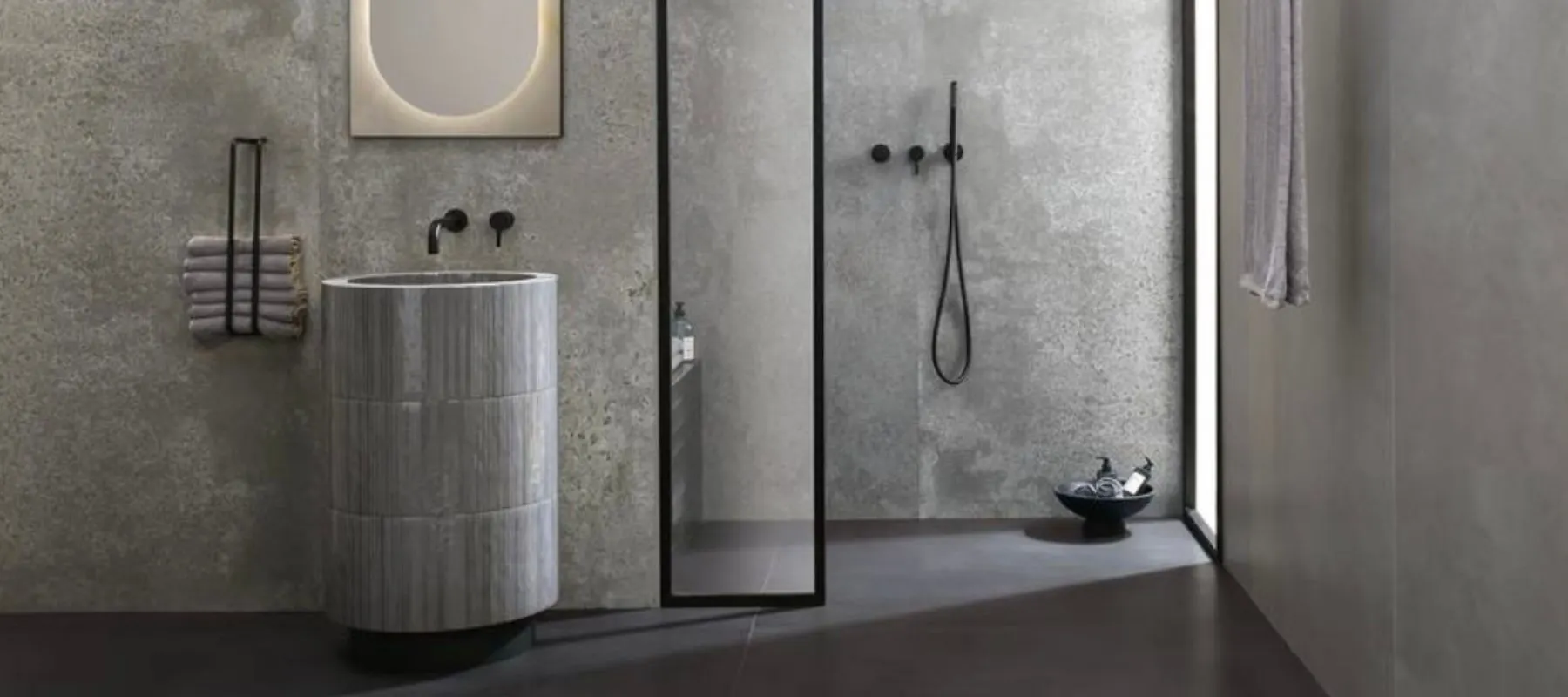 Doccia walk-in con piatto a filo pavimento e rivestimento effetto cemento grigio