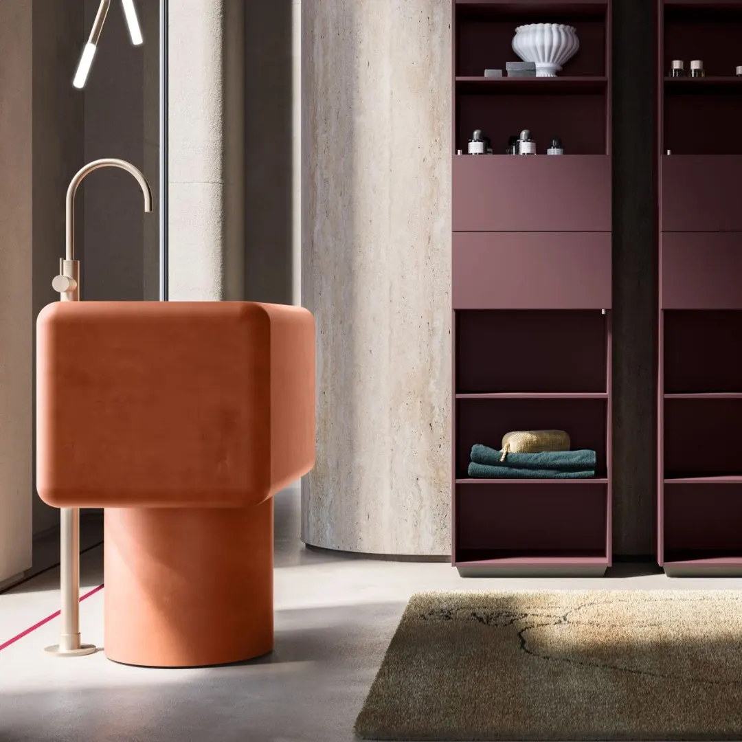 Lavabo freestanding in terracotta con colonne bordeaux e parete effetto pietra
