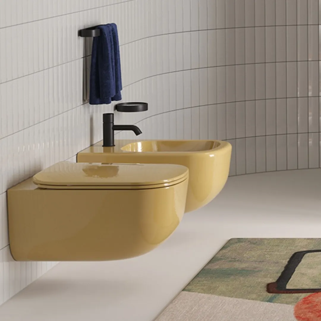 Vaso e bidet sospesi in ceramica gialla senape con miscelatore nero opaco